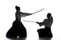 Man and woman fighting and training aikido on white studio background