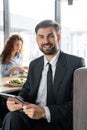 Businesspeople having business lunch at restaurant sitting man close-up holding digital tablet looking camera smiling Royalty Free Stock Photo