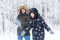 Love, relationship, season and friendship concept - man and woman having fun and playing with snow in winter forest Royalty Free Stock Photo