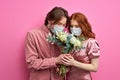 two man and woman in medical masks trying to smell the scent of flowers Royalty Free Stock Photo