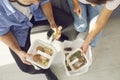 Man and woman office workers sitting on sofa and eating healthy dinner delivered by food service