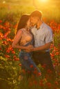 Man and woman in poppy field at sunset, romance Royalty Free Stock Photo