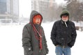 Man and woman in senior years walking on blizzard day in park