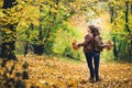 Loving happy couple in autumn in park holding autumn maple leaves in hands. Royalty Free Stock Photo