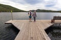 Man and women Tourists at the pier on the beautiful Ural Lake Teren Kul against the background of the Ilmensky ridge.