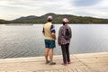 Man and women Tourists at the pier on the beautiful Ural Lake Teren Kul against the background of the Ilmensky ridge.