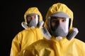 Man and woman wearing chemical protective suits on background. Virus research