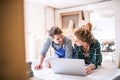 Young couple with laptop in the carpenter workroom. Royalty Free Stock Photo