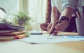 Man and women working on wooden desk in office in morning light. Royalty Free Stock Photo