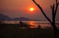 A man in wood fishing boat in the water and sunset Royalty Free Stock Photo