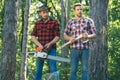 Man woodcutter holding ax. Axe in lumberjack hands cutting wood. Lumberman with a chainsaw in forest. Concept of a Royalty Free Stock Photo