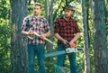 Man woodcutter holding ax. Axe in lumberjack hands cutting wood. Lumberman with a chainsaw in forest. Concept of a Royalty Free Stock Photo