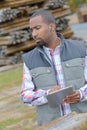 Man in woodyard with tablet computer Royalty Free Stock Photo