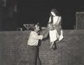 Man wooing woman sitting on brick wall