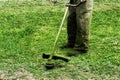 Man in work clothes mows green grass with a trimmer Royalty Free Stock Photo