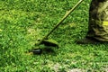 Man in work clothes mows green grass with a trimmer Royalty Free Stock Photo