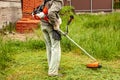 Man  worker mowing grass with trimmer Royalty Free Stock Photo
