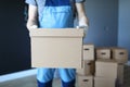 Man in work clothes is standing in office with box