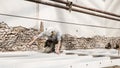 Man at work, construction worker wear a helmet, check the measurements and distances of the beams at the base of the foundations Royalty Free Stock Photo