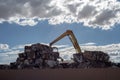 Crane stacking cumes of compressed metal at recycling center