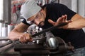 Man work with file rasp metal iron pipe gripped in vice on workbench table in garage workshop, do it yourself concept, hands close Royalty Free Stock Photo