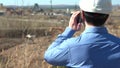 A Man in a Work Helmet Inspects a Construction Site