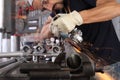 Man work in home workshop garage with angle grinder, goggles and construction gloves, sanding metal makes sparks closeup, diy and Royalty Free Stock Photo