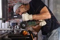 Man work in home workshop garage cut metal pipe, goggles and construction gloves, cutting metal makes sparks closeup, diy and Royalty Free Stock Photo