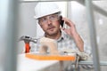 Man work, professional construction worker  with mobile cell phone, plastering tools on scaffolding, safety hard hat, gloves and Royalty Free Stock Photo