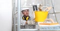 Man work, professional construction worker  with plastering tools on scaffolding, safety hard hat, gloves and protective glasses. Royalty Free Stock Photo