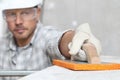 Man work, professional construction worker  with plastering tools on scaffolding, safety hard hat, gloves and protective glasses. Royalty Free Stock Photo