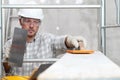 Man work, professional construction worker  with plastering tools on scaffolding, safety hard hat, gloves and protective glasses. Royalty Free Stock Photo