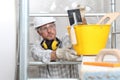 Man work, professional construction worker  with plastering tools on scaffolding, safety hard hat, gloves and protective glasses. Royalty Free Stock Photo