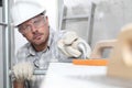 Man work, professional construction worker  with plastering tools on scaffolding, safety hard hat, gloves and protective glasses. Royalty Free Stock Photo