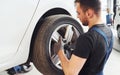 Man in work uniform changing car wheel indoors. Conception of automobile service Royalty Free Stock Photo
