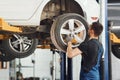 Man in work uniform changing car wheel indoors. Conception of automobile service Royalty Free Stock Photo