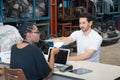 Man work with woman, he give paper note to her. Diversity of two people, caucasian business manager give paper note to African