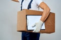 Man worker with box in hands delivery loading service work light background