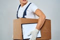 Man worker with box in hands delivery loading service work light background