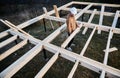 Man worker building wooden frame house on pile foundation. Royalty Free Stock Photo