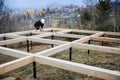 Man worker building wooden frame house on pile foundation. Royalty Free Stock Photo