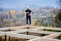 Man worker building wooden frame house on pile foundation. Royalty Free Stock Photo