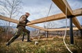 Man worker building wooden frame house on pile foundation. Royalty Free Stock Photo