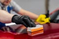 Man worker of car detailing studio applying ceramic coating on car paint with sponge applicator Royalty Free Stock Photo