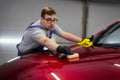 Man worker of car detailing studio applying ceramic coating on car paint with sponge applicator Royalty Free Stock Photo