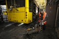 Man worker conducting technical inspection for trolleybus parked at the trolley depot hangar, depot maintenance. Kiev