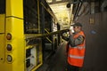 Man worker conducting technical inspection for trolleybus parked at the trolley depot hangar, depot maintenance. Kiev