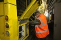 Man worker conducting technical inspection for trolleybus parked at the trolley depot hangar, depot maintenance. Kiev