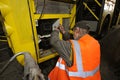 Man worker conducting technical inspection for trolleybus parked at the trolley depot hangar, depot maintenance. Kiev