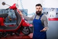 Man worker demonstrating motorbikes and scooters Royalty Free Stock Photo